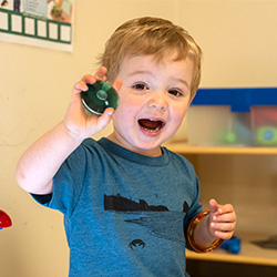 young boy playing with colorful toys in a daycare classroom.