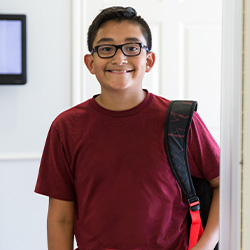 kindergarten boy standing with backback