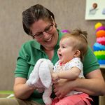 teacher holding infant on her lap