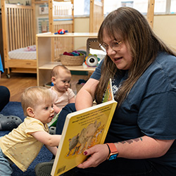 Teacher reading book to toddlers during small group story time activity