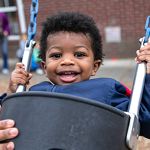 toddler boy swinging in swing