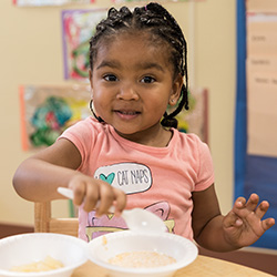 Child eating lunch at classroom table