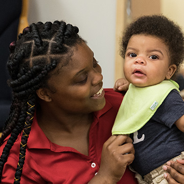 Acquisitions teacher holding baby boy