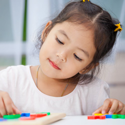 Niña joven trabajando en un rompecabezas