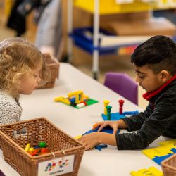 Children working together with hands-on learning activity at classroom table