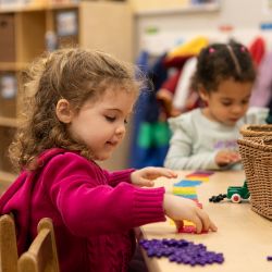 Young child working with colorful pieces during early learning activity