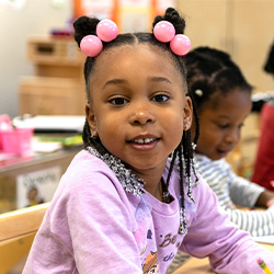young girl smiling at the camera in class