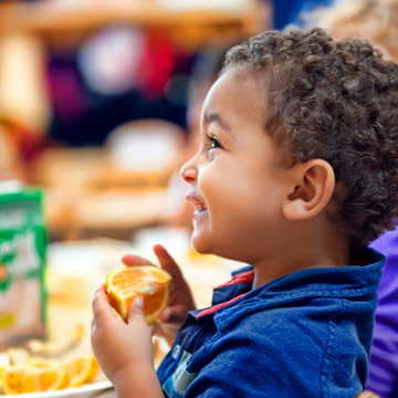 little boy eating an orange